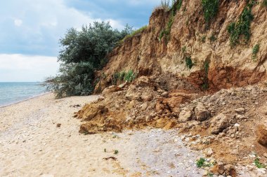 Çevreye zararlı bir bölgede dağ heyelan. Yeryüzündeki büyük çatlaklar, toprak yolu kapatan büyük katmanların inişi. Dağ yamacının yamacında baraj tehlikesi