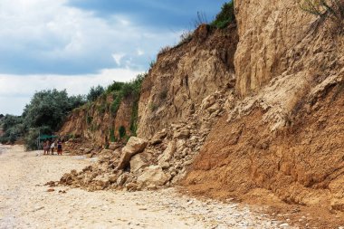 Çevreye zararlı bir bölgede dağ heyelan. Yeryüzündeki büyük çatlaklar, toprak yolu kapatan büyük katmanların inişi. Dağ yamacının yamacında baraj tehlikesi