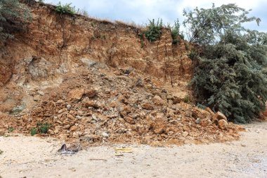 Çevreye zararlı bir bölgede dağ heyelan. Yeryüzündeki büyük çatlaklar, toprak yolu kapatan büyük katmanların inişi. Dağ yamacının yamacında baraj tehlikesi