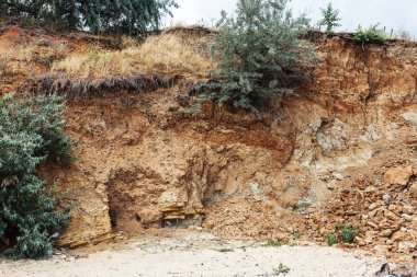 Çevreye zararlı bir bölgede dağ heyelan. Yeryüzündeki büyük çatlaklar, toprak yolu kapatan büyük katmanların inişi. Dağ yamacının yamacında baraj tehlikesi