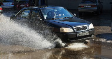 Odessa, Ukrayna -3 Temmuz 2018: yağmur fırtına tarafından neden olduğu sel sırasında su dolu bir yolda araba sürmek. Arabalar sokaklarda sel su üzerinde yüzer. Sıçramak üstünde belgili tanımlık makine. Büyük bir su birikintisi olan sular altında şehir yol