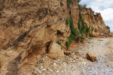 Çevreye zararlı bir bölgede dağ heyelan. Yeryüzündeki büyük çatlaklar, toprak yolu kapatan büyük katmanların inişi. Dağ yamacının yamacında baraj tehlikesi