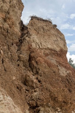 Çevreye zararlı bir bölgede dağ heyelan. Yeryüzündeki büyük çatlaklar, toprak yolu kapatan büyük katmanların inişi. Dağ yamacının yamacında baraj tehlikesi