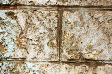 Alçı tuğla duvarın boş eski sanat dokusu. Yaprak dokusuyla boyanmış taş tuğla duvarın çatlaklarıyla kötü çizilmiş yüzey. Hasarlı alçıyla binanın ön cephesini ovaladım.