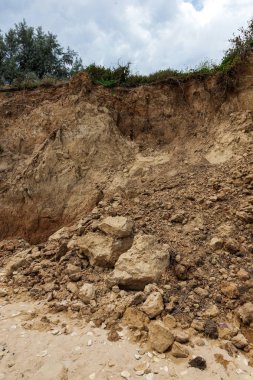 Çevreye zararlı bir bölgede dağ heyelan. Yeryüzündeki büyük çatlaklar, toprak yolu kapatan büyük katmanların inişi. Dağ yamacının yamacında baraj tehlikesi