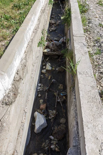 污水从破碎管道进入地面 排出水泥 造成污染 在城市街道旁排污的水泥通道 流行病的生态问题 — 图库照片