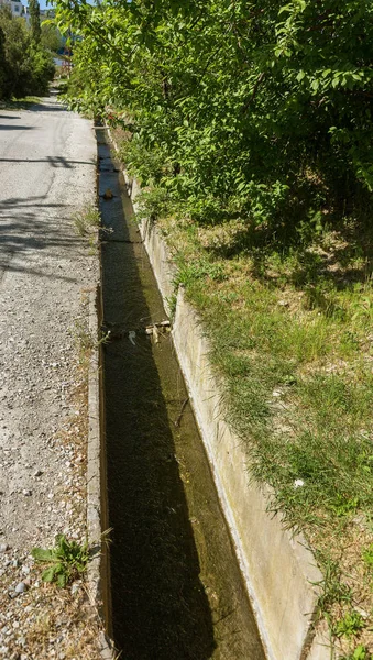 Dirty Sewage entering ground from broken pipeline to drain cement causes pollution. Cement channel for discharging dirty sewage on side of city street. ecological problem of epidemic