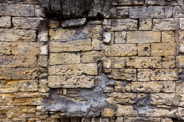 An old destroyed wall with large large cracks. Background of crack on an old wall as background for creative design. Destroyed cracked wall of building after earthquake and hurricane