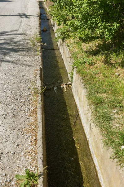 Dirty Sewage entering ground from broken pipeline to drain cement causes pollution. Cement channel for discharging dirty sewage on side of city street. ecological problem of epidemic