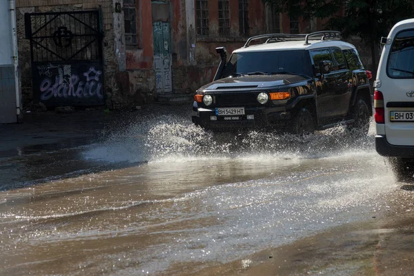 Odessa, Ukrayna -3 Temmuz 2018: yağmur fırtına tarafından neden olduğu sel sırasında su dolu bir yolda araba sürmek. Arabalar sokaklarda sel su üzerinde yüzer. Sıçramak üstünde belgili tanımlık makine. Büyük bir su birikintisi olan sular altında şehir yol
