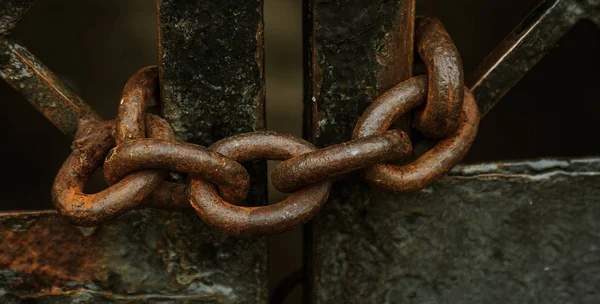 旧的锈迹斑斑的厚铁链保护着铁门 旧铁网路上的链条可防止未经授权的访问 生锈的铁链 — 图库照片