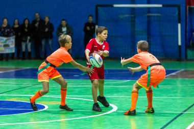 Odessa, Ukrayna - Decemb 25, 2018: genç çocuk oyun rugby şehir okul Derby kapalı odasında oynarken. Çocuk spor. Çocuk rugby 5 oyun. Çocuk zafer için mücadele. Sağlıklı yaşam tarzı