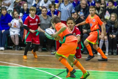 Odessa, Ukrayna - Decemb 25, 2018: genç çocuk oyun rugby şehir okul Derby kapalı odasında oynarken. Çocuk spor. Çocuk rugby 5 oyun. Çocuk zafer için mücadele. Sağlıklı yaşam tarzı