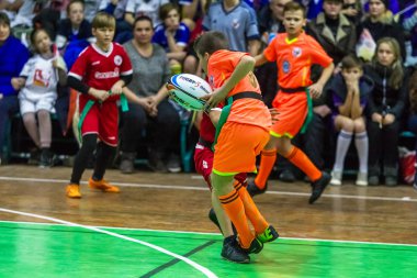 Odessa, Ukrayna - Decemb 25, 2018: genç çocuk oyun rugby şehir okul Derby kapalı odasında oynarken. Çocuk spor. Çocuk rugby 5 oyun. Çocuk zafer için mücadele. Sağlıklı yaşam tarzı