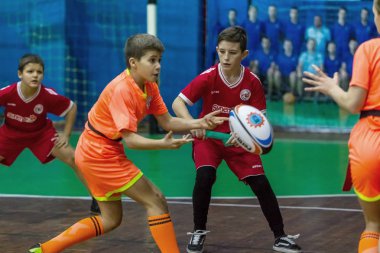 Odessa, Ukrayna - Decemb 25, 2018: genç çocuk oyun rugby şehir okul Derby kapalı odasında oynarken. Çocuk spor. Çocuk rugby 5 oyun. Çocuk zafer için mücadele. Sağlıklı yaşam tarzı