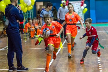 Odessa, Ukrayna - Decemb 25, 2018: genç çocuk oyun rugby şehir okul Derby kapalı odasında oynarken. Çocuk spor. Çocuk rugby 5 oyun. Çocuk zafer için mücadele. Sağlıklı yaşam tarzı