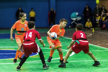 Odessa, Ukrayna - Decemb 25, 2018: genç çocuk oyun rugby şehir okul Derby kapalı odasında oynarken. Çocuk spor. Çocuk rugby 5 oyun. Çocuk zafer için mücadele. Sağlıklı yaşam tarzı