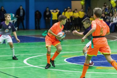 Odessa, Ukrayna - Decemb 25, 2018: genç çocuk oyun rugby şehir okul Derby kapalı odasında oynarken. Çocuk spor. Çocuk rugby 5 oyun. Çocuk zafer için mücadele. Sağlıklı yaşam tarzı