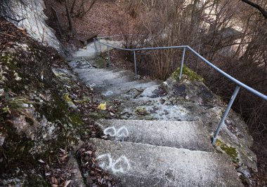 Eski, açık, taştan bir merdiven. Taş, eski merdivenlerin çimento basamaklarında yıpranma ve yıpranma izleri var. Eski taş bir merdiven, eski kırık basamaklar. Seçici odak