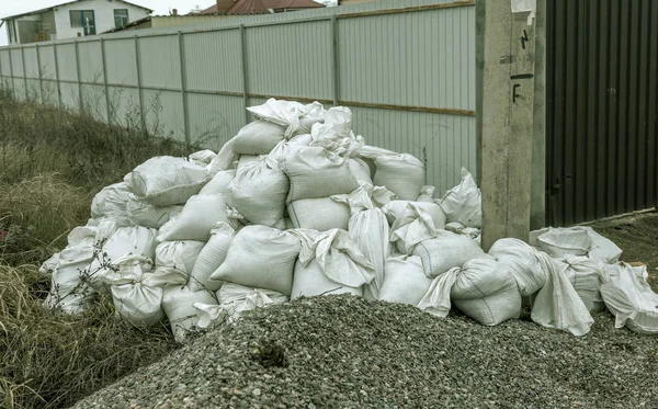 白色的建筑袋的建筑垃圾被倾倒在正在施工的围栏附近的堆里 污染概念 垃圾堆垃圾堆在垃圾堆里的一堆垃圾 非法倾倒废物问题回收 — 图库照片