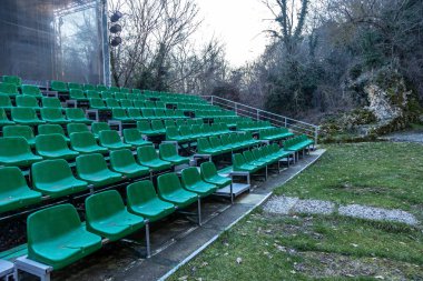 Yaz Tiyatrosu tribünlerde boş eski plastik sandalyeler. Çok boş koltuk amfitiyatro tribünlerde seyirci için. Boş plastik sandalyeler, seyirciler için oturma. Plastik kap
