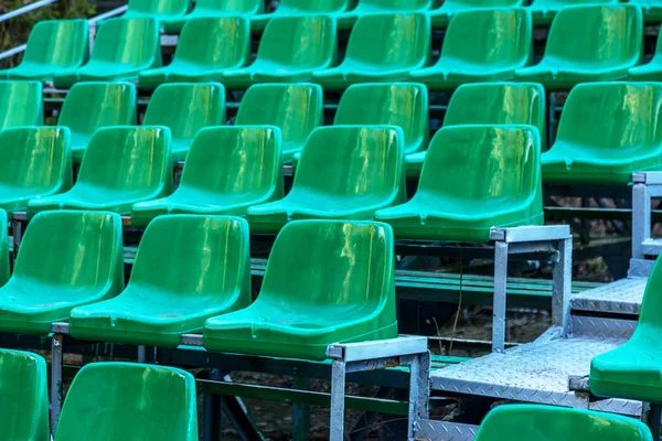 Empty old plastic chairs in the stands of the summer theater. Many empty seats for spectators in the stands of the amphitheater. Empty plastic chairs, seating for the audience. Plastic pot
