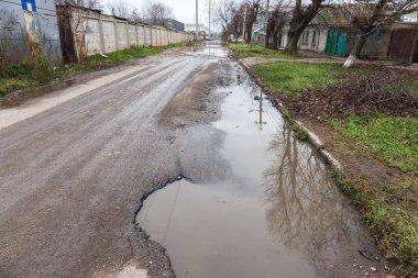 Çok kötü kalite yol çukurların ile. Asfalt, kötü asfalt delik. Çukur, güvensiz, delik yol. Ulaşım, yollar, imha hareketi tarafından araba konsepti riski. Kötü yollar kavramı