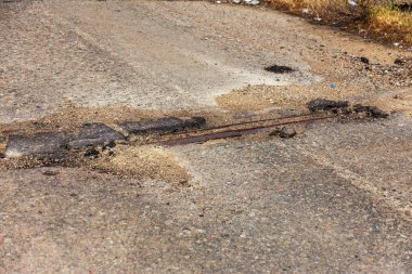 Çok kötü kalite yol çukurların ile. Asfalt, kötü asfalt delik. Çukur, güvensiz, delik yol. Ulaşım, yollar, imha hareketi tarafından araba konsepti riski. Kötü yollar kavramı