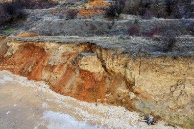 Karadeniz kıyısındaki heyelan bölgesi. Deniz taşı kabuğu. Yağmur mevsiminde doğal afetler bölgesi. Büyük toprak kütleleri tepenin yamacında kayıp evleri yok ediyor. Heyelan - yaşam tehdidi
