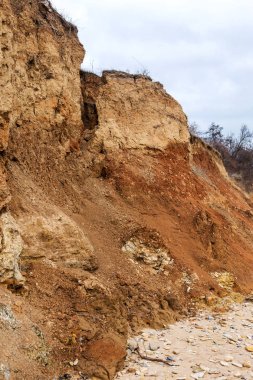 Karadeniz kıyısındaki heyelan bölgesi. Deniz taşı kabuğu. Yağmur mevsiminde doğal afetler bölgesi. Büyük toprak kütleleri tepenin yamacında kayıp evleri yok ediyor. Heyelan - yaşam tehdidi