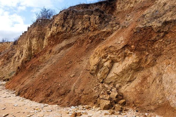 Landslide zone on Black Sea coast. Rock of sea rock shell. Zone of natural disasters during rainy season. Large masses of earth slip along slope of hill, destroy houses. Landslide - threat to life