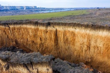 Karadeniz kıyısındaki heyelan bölgesi. Deniz taşı kabuğu. Yağmur mevsiminde doğal afetler bölgesi. Büyük toprak kütleleri tepenin yamacında kayıp evleri yok ediyor. Heyelan - yaşam tehdidi