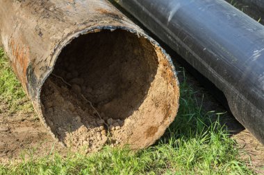 Eski büyük su boruları parçaları. Sonra uzun yıllar çalışma aşınmış metal boru yok. Paslı çelik boru delik metal korozyon ile. Seçici odak.