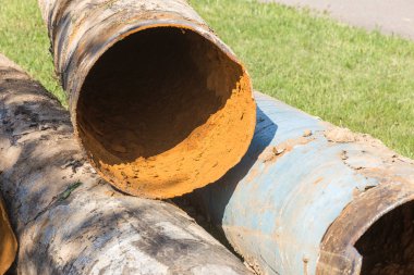 Eski büyük su boruları parçaları. Sonra uzun yıllar çalışma aşınmış metal boru yok. Paslı çelik boru delik metal korozyon ile. Seçici odak.