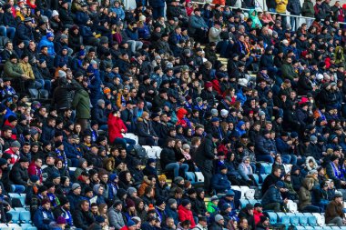 ODESSA, UKRAINE -2 Mart 2019: Shakhtar (Donetsk) maçı sırasında stadyumun tribünlerinde taraftarlar toplandı. Stadyumdaki izleyiciler. Fayer, stadyumun ışıkları yanıyor.