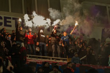 ODESSA, UKRAINE -2 Mart 2019: Shakhtar (Donetsk) maçı sırasında stadyumun tribünlerinde taraftarlar toplandı. Stadyumdaki izleyiciler. Fayer, stadyumun ışıkları yanıyor.