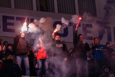 ODESSA, UKRAINE -2 Mart 2019: Shakhtar (Donetsk) maçı sırasında stadyumun tribünlerinde taraftarlar toplandı. Stadyumdaki izleyiciler. Fayer, stadyumun ışıkları yanıyor.