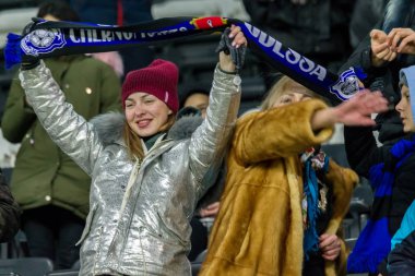 ODESSA, UKRAINE -2 Mart 2019: Shakhtar (Donetsk) maçı sırasında stadyumun tribünlerinde taraftarlar toplandı. Stadyumdaki izleyiciler. Fayer, stadyumun ışıkları yanıyor.