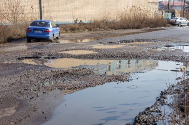 Odessa, Ukrayna 5 Mart 2019: Asfalt yol ile çukurların dondurma ve çözme döngüsü sırasında belgili tanımlık kış nedeniyle zarar görmüş. Arabalar su çukurlara kötü yol