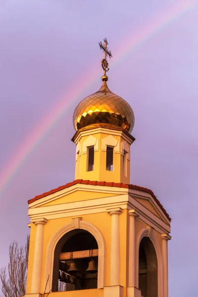 雨の後明るいマルチカラー虹の背景設定夕日の光線で正統派キリスト教会の黄金のドーム 良いニュースは — ストック写真