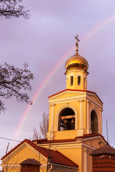 雨の後明るいマルチカラー虹の背景設定夕日の光線で正統派キリスト教会の黄金のドーム 良いニュースは — ストック写真