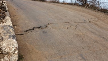 Büyük çatlaklar, cips, tabak. Kırık asfalt heyelan bir depremden sonra değiştirdi. Yolda tehlikeli derin çatlaklar. Yol kapalı. Deprem sonrası terk edilmiş yol yok asfalt üzerinde çatlaklar oluşan tablo