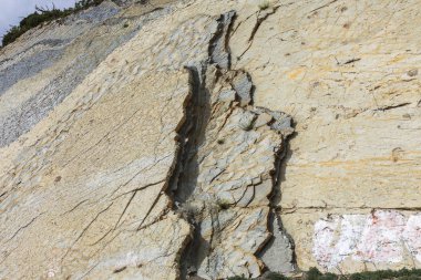 Şeyl dağlar çukurlar çimento. Taş duvar dokusu. Büyük bir taş çatlaklar, taş ridge ayrılması. Taş duvar doku arka plan. Taş yapı çimento üretimi için