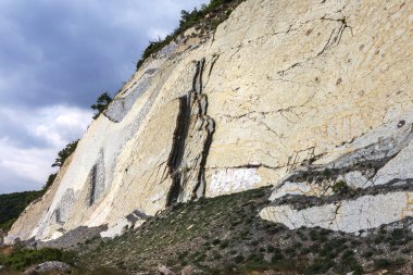 Şeyl dağlar çukurlar çimento. Taş duvar dokusu. Büyük bir taş çatlaklar, taş ridge ayrılması. Taş duvar doku arka plan. Taş yapı çimento üretimi için