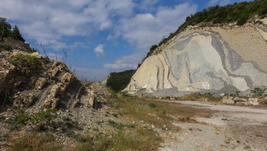 Şeyl dağlar çukurlar çimento. Taş duvar dokusu. Büyük bir taş çatlaklar, taş ridge ayrılması. Taş duvar doku arka plan. Taş yapı çimento üretimi için