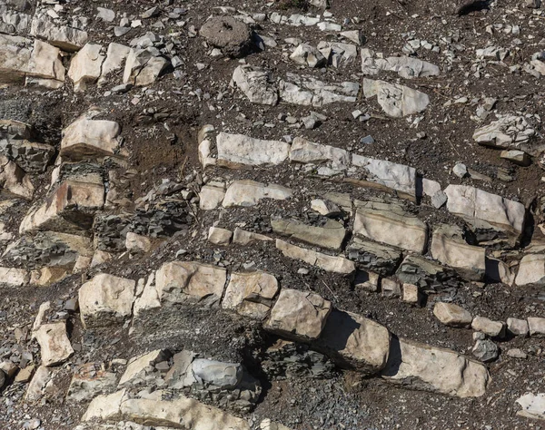 Shale mountains cement pits. The texture of the stone wall. Large stone cracks, the separation of the stone ridge. Background of stone wall texture. Stone for construction cement production