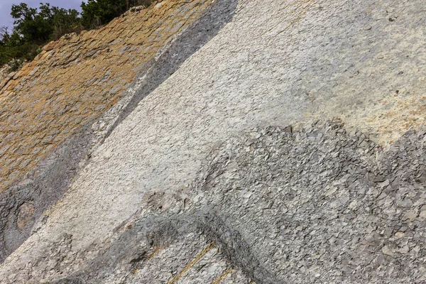 Shale mountains cement pits. The texture of the stone wall. Large stone cracks, the separation of the stone ridge. Background of stone wall texture. Stone for construction cement production