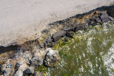 Bir deprem ve kış ve şiddetli yıkıcı frost güçlü fırtınada sonra denize süpürüp götürdü heyelan yolda asfalt. Deniz boyunca yol Destroyed asfalt yol kapalı. Kırık asfalt çatlamak ve toprak kaymaları