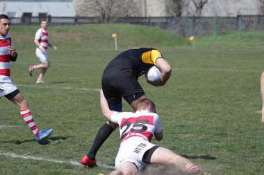 Odessa, Ukrayna - 6 Nisan 2019: Milli takım amentü (Odessa)-Olimpiyat (Kharkov) Rugby Şampiyonası. Gergin mücadele oyuncu topu için rugby testi sırasında. Stadyum yeşil alan üzerinde dinamik oyun