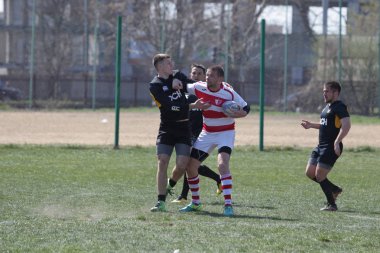 Odessa, Ukrayna - 6 Nisan 2019: Milli takım amentü (Odessa)-Olimpiyat (Kharkov) Rugby Şampiyonası. Gergin mücadele oyuncu topu için rugby testi sırasında. Stadyum yeşil alan üzerinde dinamik oyun